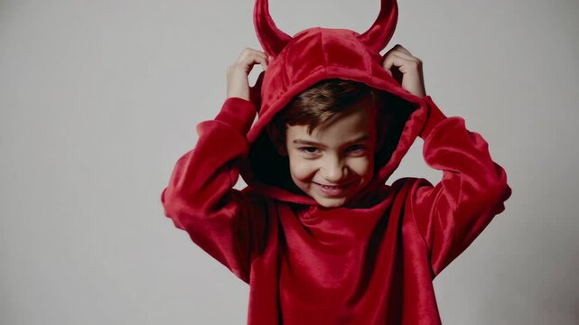 Playful child in red devil costume with expressions of mischief and joy