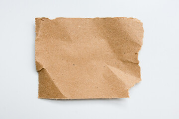 Brown torn paper on white background with textured surface and rough edges
