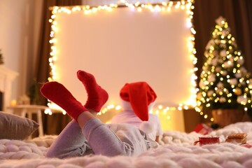 Child watching movie using video projector at home. Cozy Christmas atmosphere