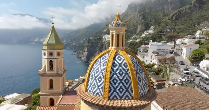 Closeup of colorful dome and tower bell of the church of San Gennaro in the main square of Praiano. This parish is located in the Amalfi Coast, Campania, Italy. 