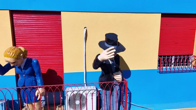 Traditional Caminito passage with tourists and panoramic view of the city from La Boca neighborhood. Aerial camera rises from the street