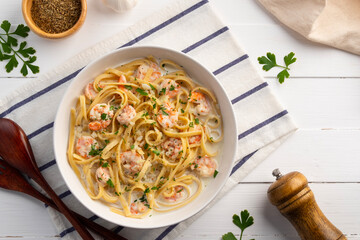 Fettuccine pasta with shrimp in white cream sauce.Creamy Shrimps Spaghetti carbonara sauce in white plate.Top view.