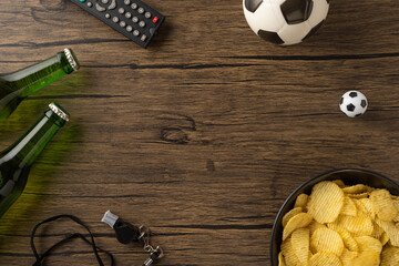 A setup for enjoying football at home featuring snacks, beer bottles, and soccer items