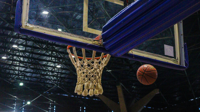 A basketball bouncing off the hoop after a missed shot, captured mid-air with dynamic movement, showcasing energy and action in the game