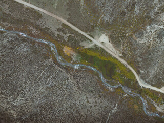 dirt road in the mountains next to a river