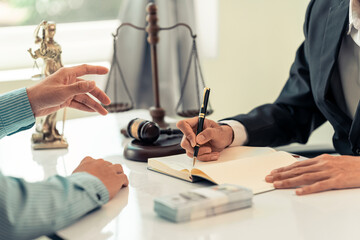 Consulting and Justice. Lawyer and businessman working consulting and negotiating. Close-up of gavel. Male lawyer or judge reading case in documents on desk in modern office.