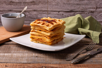 Caramel sauce drizzled over a stack of waffles.