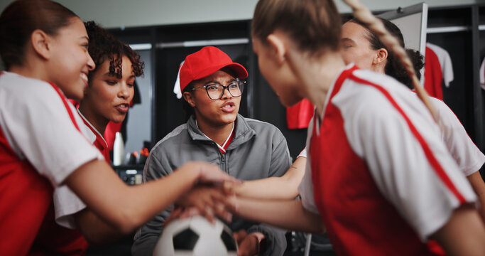 Women, coach and hands together with soccer team for motivation or collaboration in locker room. Female people, group or sport players piling with stack or ball in huddle for game plan or match - Powered by Adobe