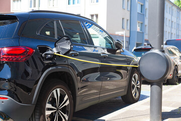 Charging electric car at the city charging station.