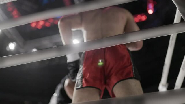 Boxer waiting in corner of boxing ring