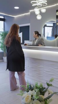 Patient leaving reception desk at modern dental clinic