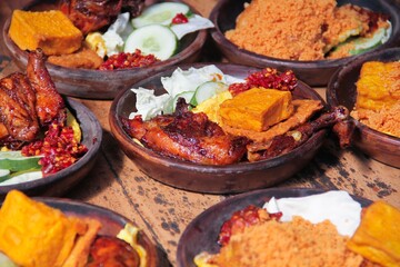 Ayam Bakar Madu, Roasted Chicken with Honey with chili sauce, tofu, vegetables served on a wooden...