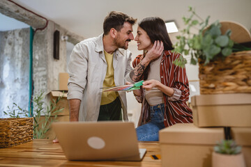 couple use laptop and color palette to choose color for paint wall