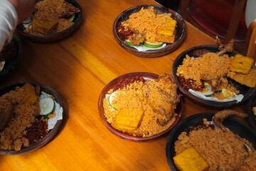 Ayam Bakar Madu, Roasted Chicken with Honey with chili sauce, tofu, vegetables served on a wooden...
