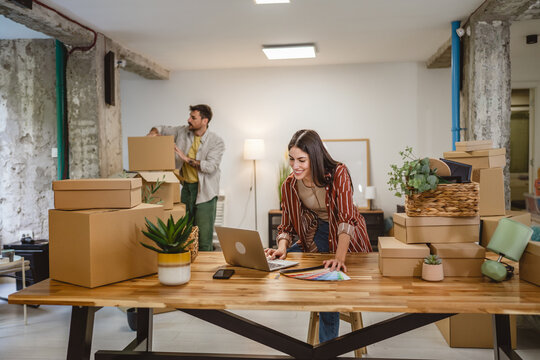 woman use laptop and color palette choice wall color, while man unpack