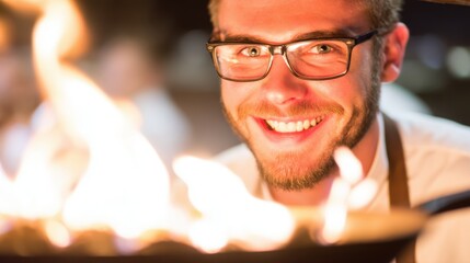 Grinning chef showcasing flambé technique, joyful culinary expert in a bustling kitchen with vibrant flames, dynamic atmosphere.