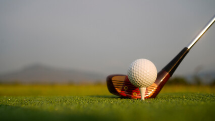 Golf clubs and balls on a green lawn in a beautiful golf course with morning sunshine.