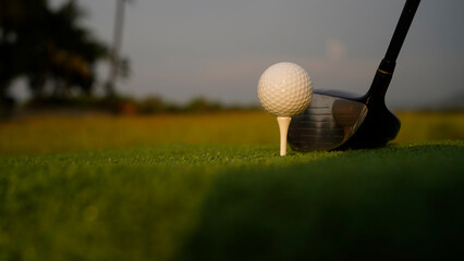 Golf clubs and balls on a green lawn in a beautiful golf course with morning sunshine.