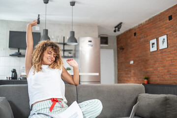 Freelancer woman stretching on sofa after working from home
