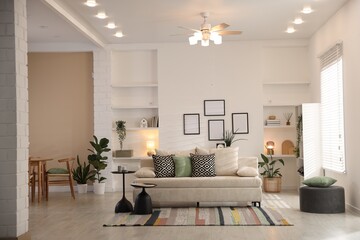 Comfortable sofa with cushions in room. Interior design