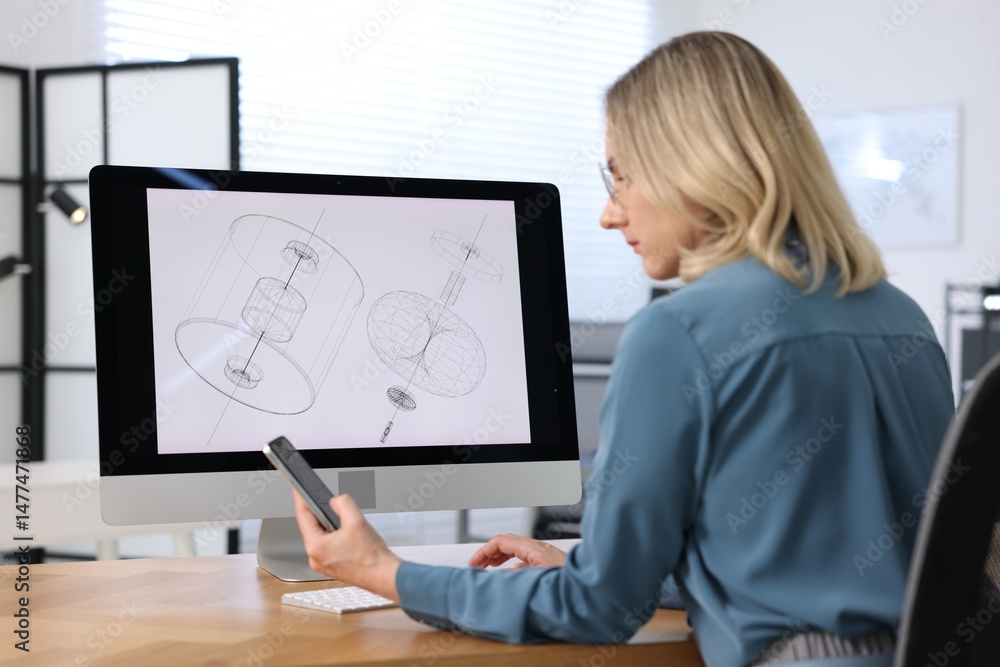 Poster engineer working with devices at table in office