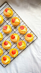 Mini Strawberry, pineapple, and orange Shortcake Tartlets with vanilla custard isolated on white cloth