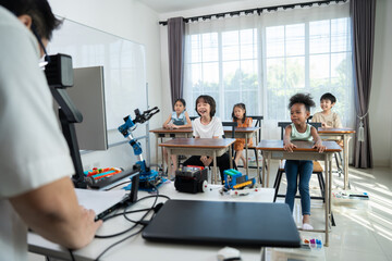 Young Engineers: multi ethnic Children engrossed in building and testing small robotics, showcasing...