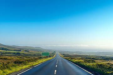 Empty road stretching to the horizon under a clear blue sky, featuring a blank green road sign. Ideal for travel, journey, and freedom concepts.