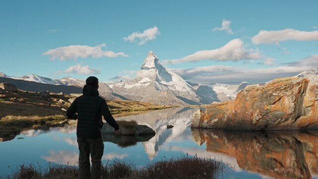 Traveler man standing and enjoying on Stellisee Lake with Matterhorn mountain in the morning at Switzerland