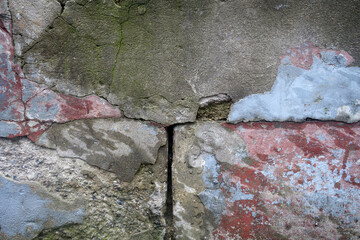Grungy wall texture with cracks and mud.