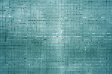 Grungy cyan colored wall made of small square tiles.