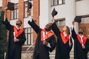 Joyful Graduates Celebrating Success by Tossing Caps in the Air at University Ceremony