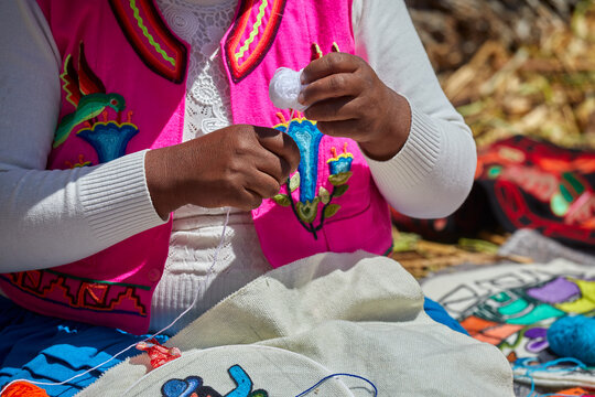 skillful Uros hands at work, delicately embroidering traditional Andean patterns. Each stitch reflects generations of cultural knowledge and artistic expression. Puno Peru