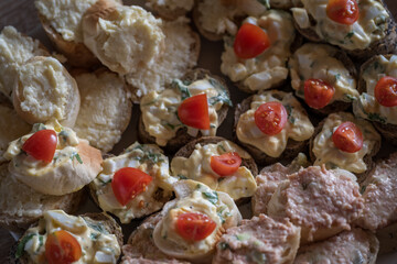 Small sandwiches with spread and tomato.