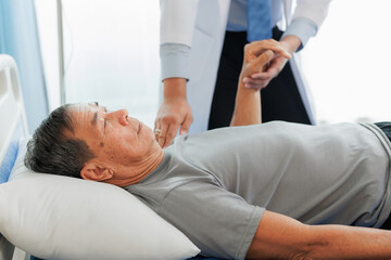 Obraz premium An elderly patient undergoes leg physiotherapy on a treatment bed while being carefully assisted and advised by a healthcare specialist.