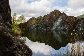 Still lake reflects dramatic rocky cliffs nature scenery peaceful water.