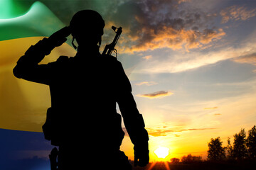 Silhouette of a soldier against the sunset with Gabon flag. National Holidays concept