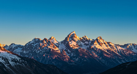 Majestic Peaks: A Breathtaking Panorama of Snow-Capped Mountain Range at Dawn