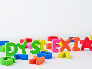 Dyslexia word bright colorful wooden toy blocks in white background. Dyslexia concept. difficulty with fast reading, writing words, education learning elementary school kids.