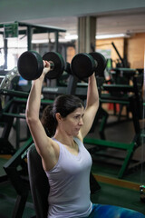 Fototapeta premium woman training exercises in gym with weights