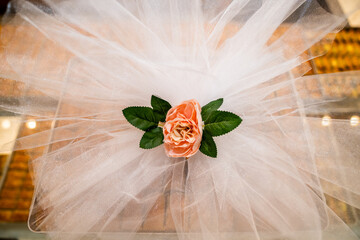 Close up view of the decorations with artificial flowers and tulle at a celebration or wedding.