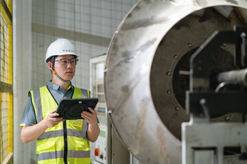 asian male engineer woking on digital tablet in factory with  Industrial fan impeller