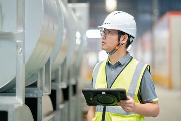 asian male engineer woking on digital tablet in factory with  Industrial fan impeller