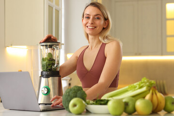 Weight loss. Woman making protein shake at table in kitchen