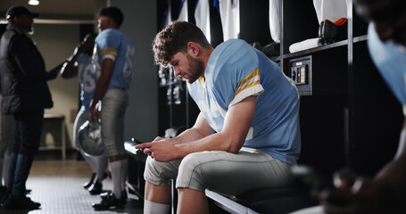 Football, sports and man with phone in locker room for text message, check notifications and match break. Player, athlete and relax with smartphone for social media scroll, online news or mobile chat