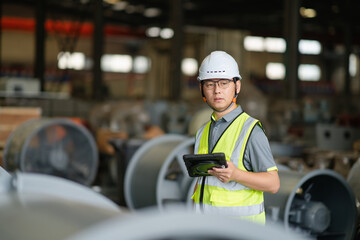 asian male engineer woking on digital tablet in factory with  Industrial fan impeller