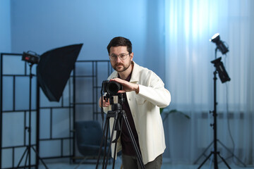 Man with professional video camera in studio