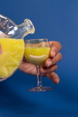 Hands pouring yellow liqueur in a glass