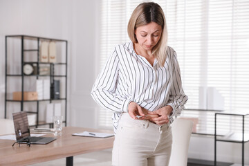 Woman making insulin injection into her belly indoors. Diabetes