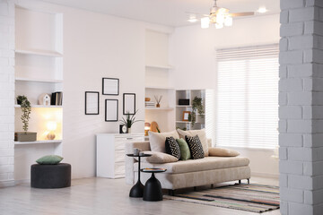 Comfortable sofa with cushions in room. Interior design